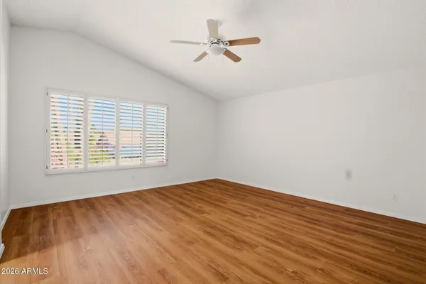 a view of an empty room with a window and a ceiling fan