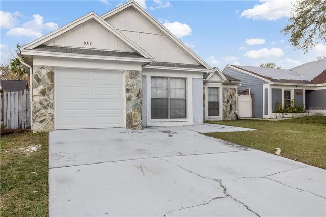a view of a white house with a large window and yard