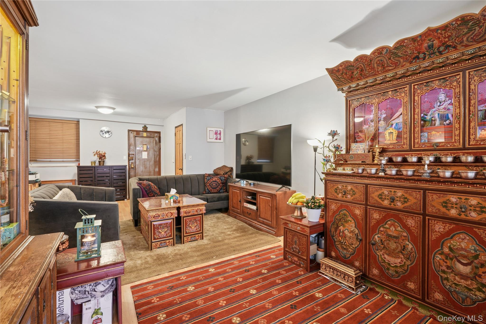 35-50 85th Street, Unit 3D Queens, NY 11372 - Photo 11 of 15 a living room with furniture a flat screen tv and kitchen view