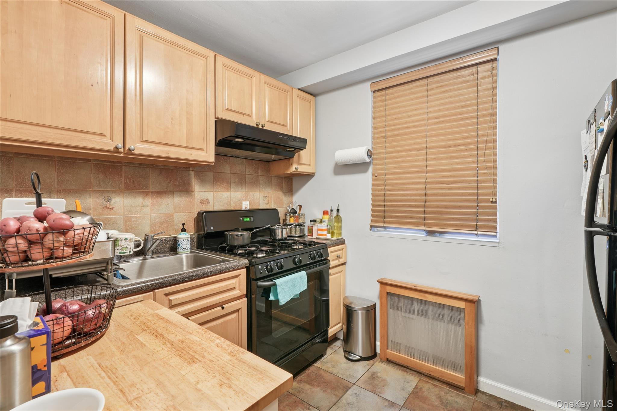 35-50 85th Street, Unit 3D Queens, NY 11372 - Photo 12 of 15 a kitchen with stainless steel appliances granite countertop a stove top oven a sink dishwasher and cabinets with wooden floor