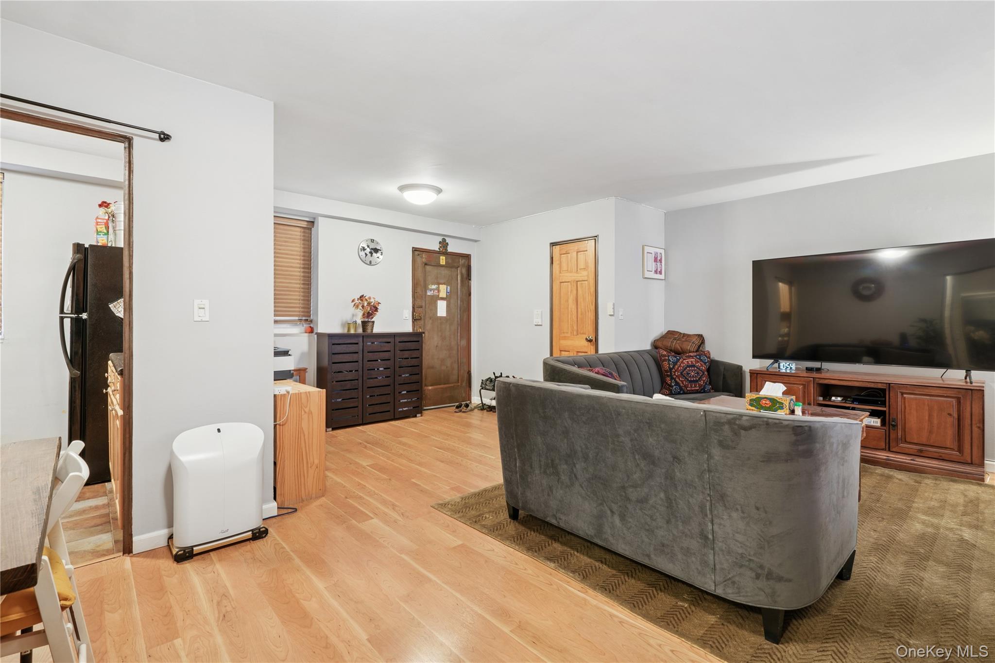 35-50 85th Street, Unit 3D Queens, NY 11372 - Photo 6 of 15 a living room with furniture and a flat screen tv