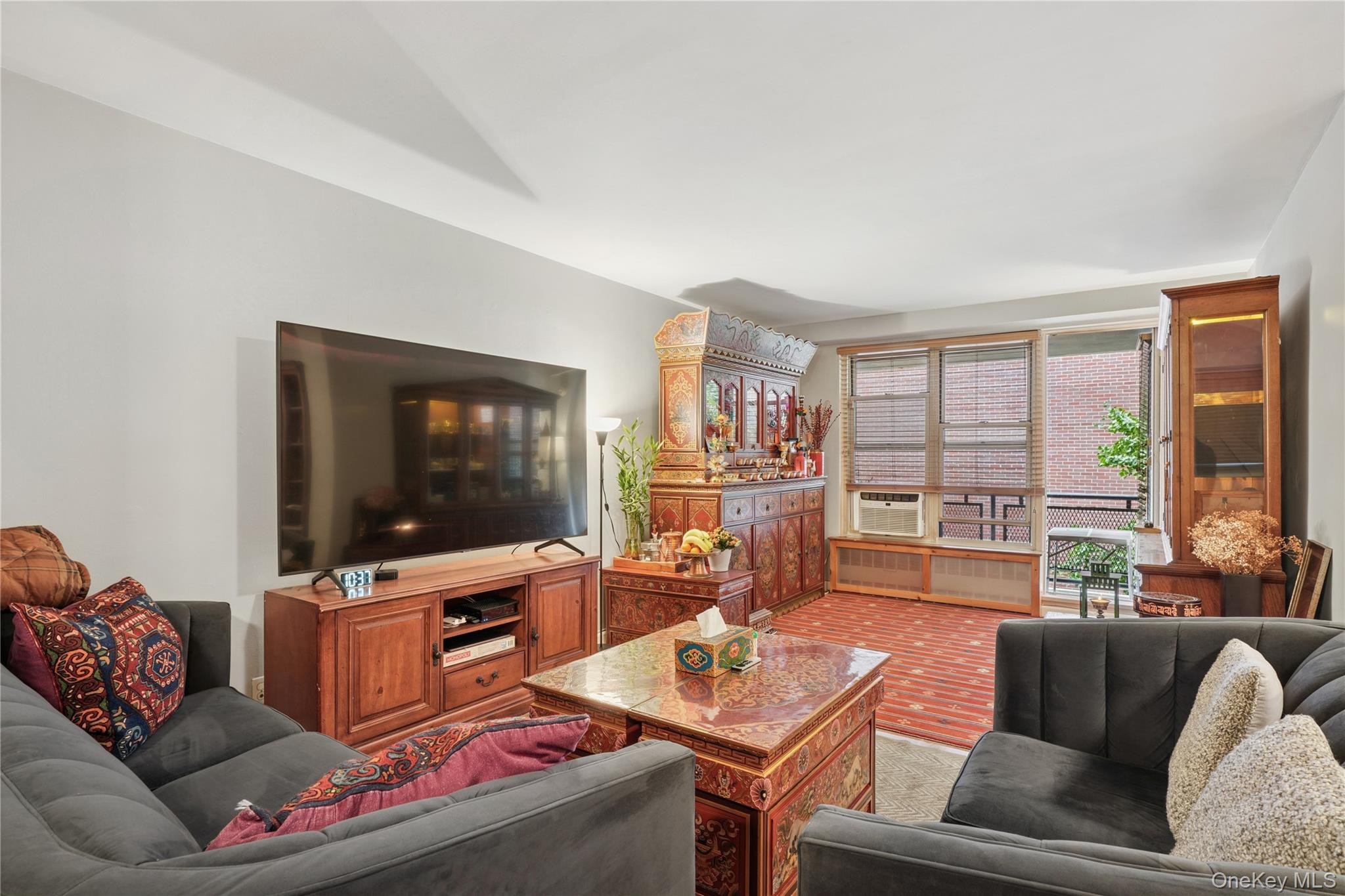 35-50 85th Street, Unit 3D Queens, NY 11372 - Photo 7 of 15 a living room with furniture and a flat screen tv