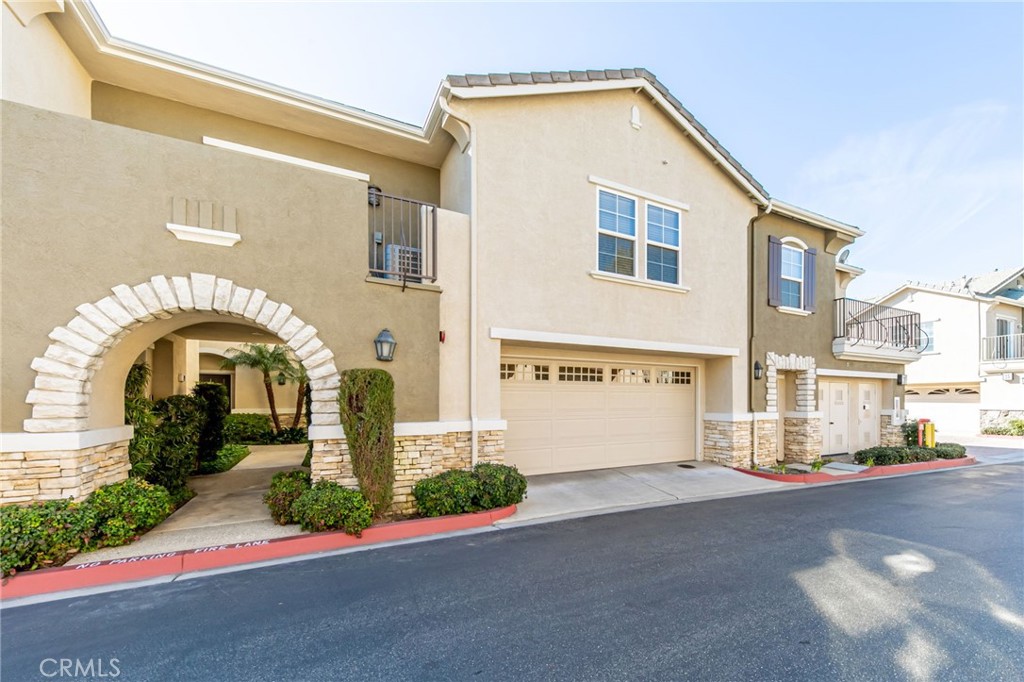 7353 Ellena West, Unit 81 Rancho Cucamonga, CA 91730 - Photo 1 of 1 a front view of a house with a garden
