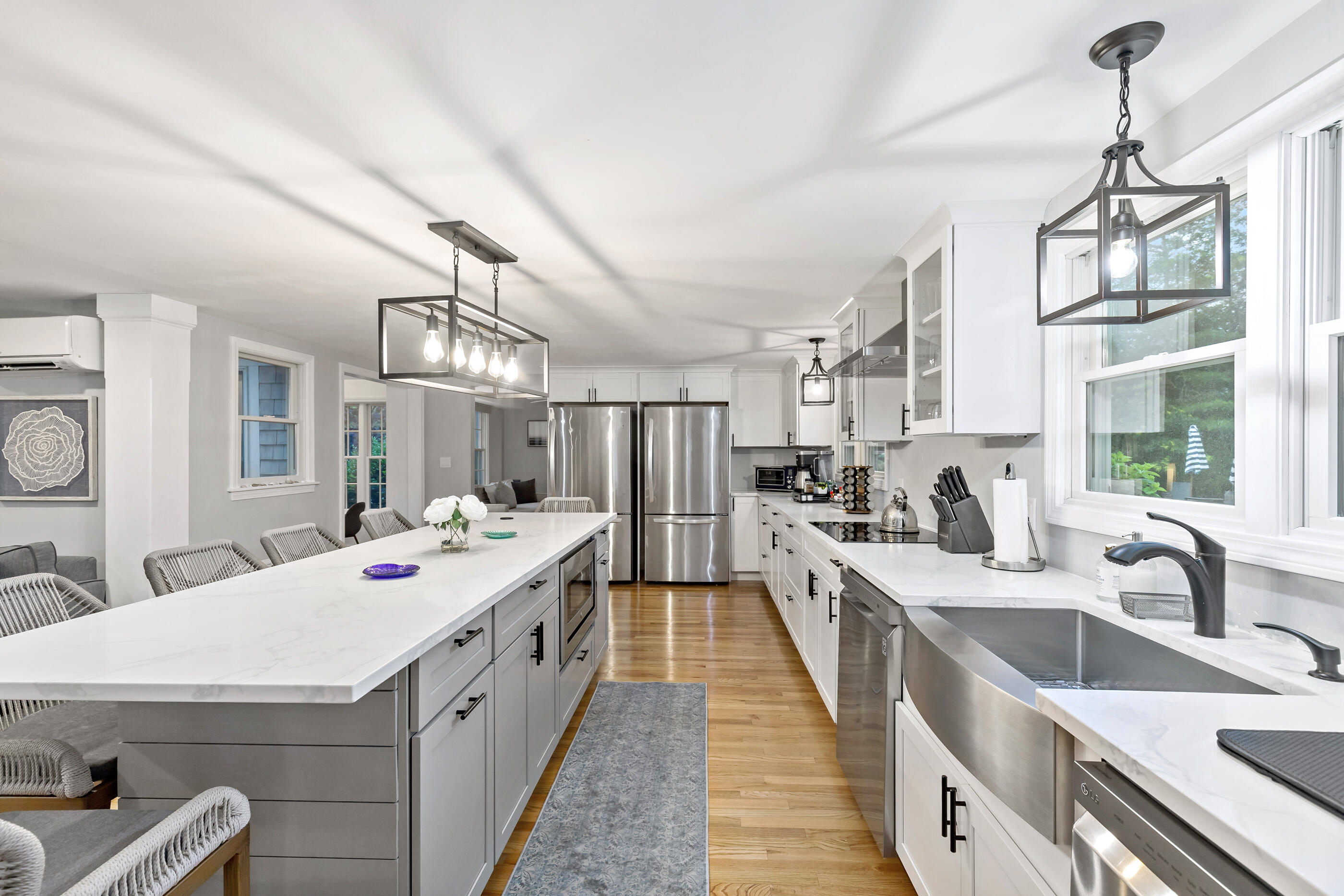 414 Eel River Road Osterville, MA 02655 - Photo 14 of 40 a large white kitchen with kitchen island a stove a sink dishwasher and white cabinets with wooden floor
