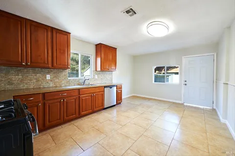 a kitchen with stainless steel appliances granite countertop a stove a sink and a refrigerator
