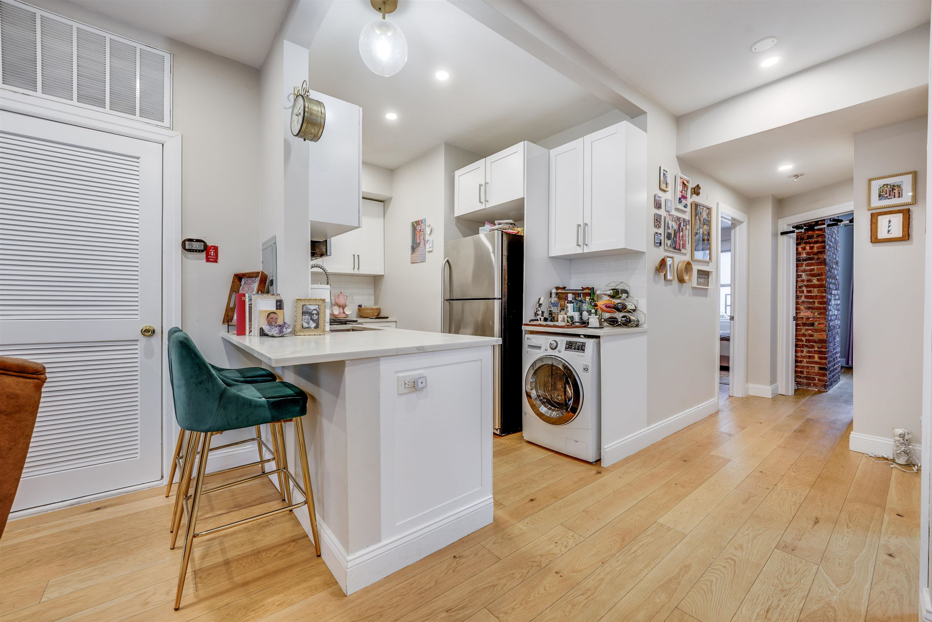 709 Monroe Street, Unit 2 Hoboken, NJ 07030 - Photo 6 of 22 a kitchen with stainless steel appliances a stove a refrigerator a sink and white cabinets with wooden floor