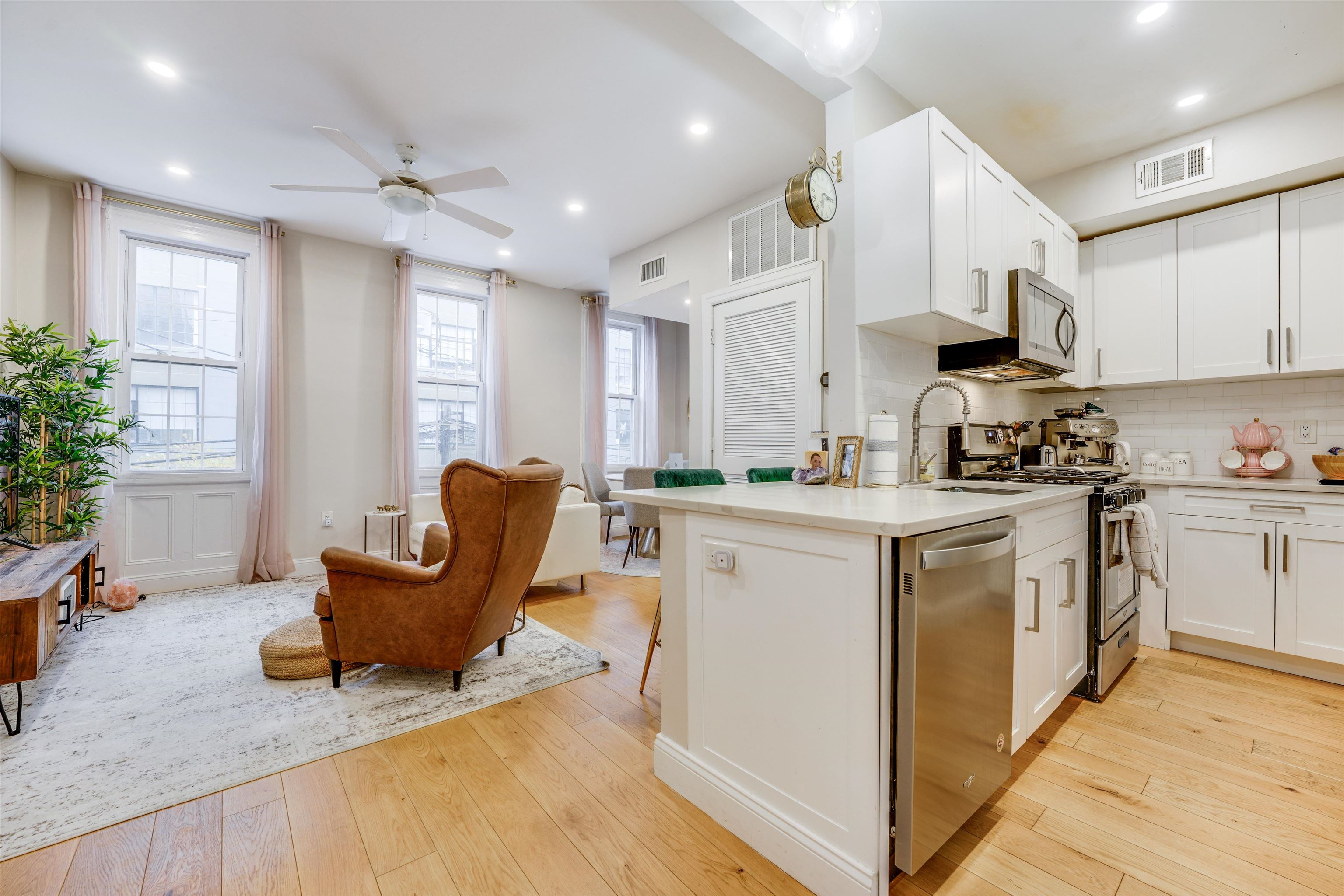 709 Monroe Street, Unit 2 Hoboken, NJ 07030 - Photo 7 of 22 a kitchen with granite countertop a white refrigerator a sink dishwasher a stove and a dining table with wooden floor