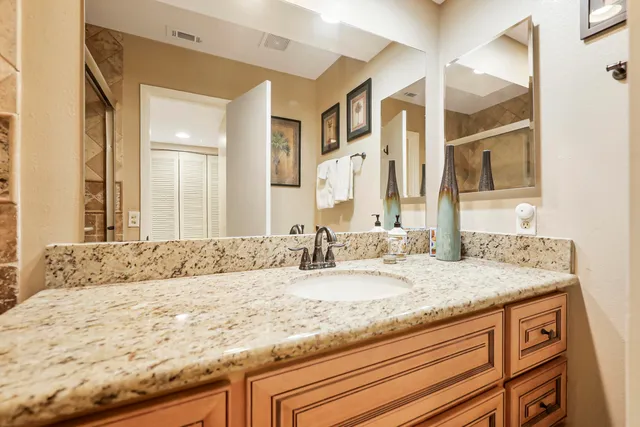 a bathroom with a granite countertop sink and a mirror