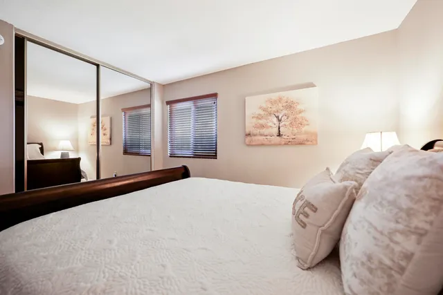 a bedroom with a large bed and a chandelier