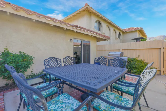 a view of a patio with table and chairs with wooden floor and plants
