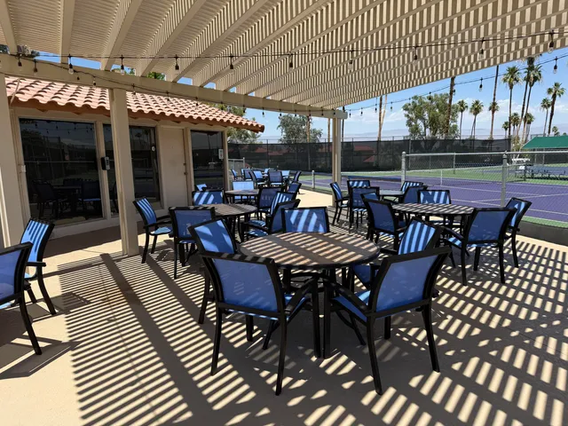a view of a tennis ground and large trees