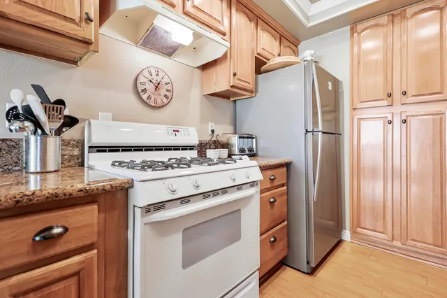 a kitchen with stainless steel appliances granite countertop a stove and a refrigerator