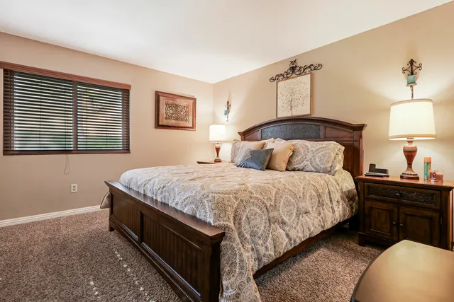 a bedroom with a bed and a lamp on dresser
