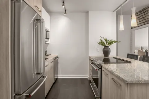 a kitchen with granite countertop a sink and a refrigerator