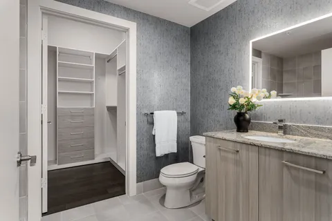 a bathroom with a granite countertop sink a toilet and a mirror
