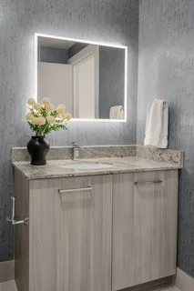 a bathroom with a granite countertop sink a toilet and a mirror