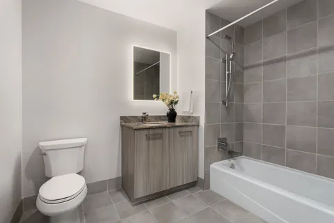a bathroom with a granite countertop toilet a sink and bathtub