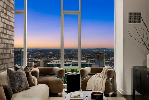 a living room with furniture and a floor to ceiling window