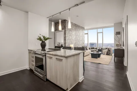 a kitchen with kitchen island granite countertop a sink stove and wooden floor
