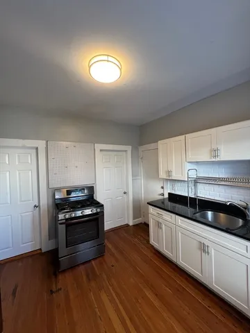a kitchen with granite countertop a stove and a sink