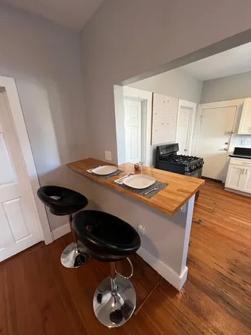 a kitchen with stainless steel appliances a table and chairs in it