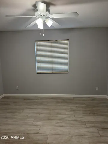 en empty room with wooden floor fan and windows