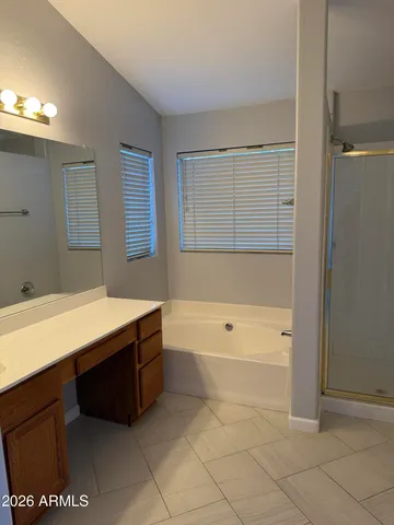 a spacious bathroom with a tub sink and mirror