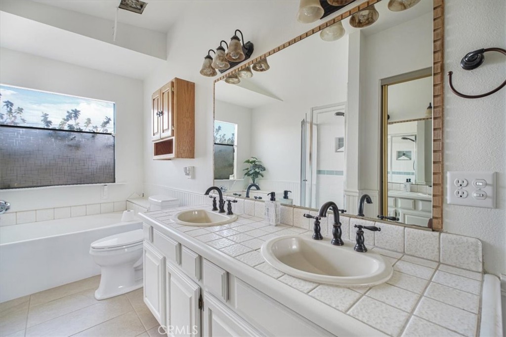 79040 Cliff Street Bermuda Dunes, CA 92203 - Photo 2 of 42 a bathroom with a granite countertop sink a toilet a mirror and bathtub