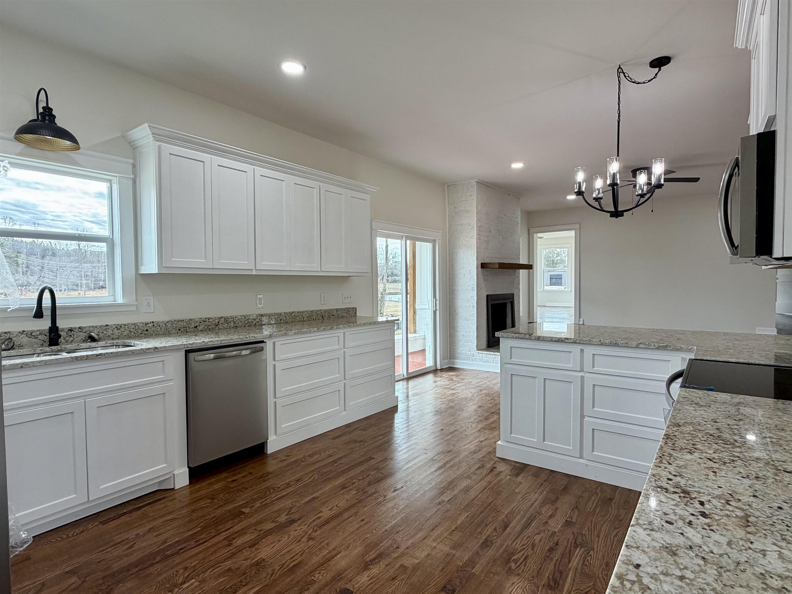172 New Bethel Road Selmer, TN 38375 - Photo 14 of 30 a kitchen with granite countertop a sink cabinets and wooden floor