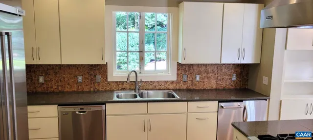 a kitchen with granite countertop white cabinets and a sink