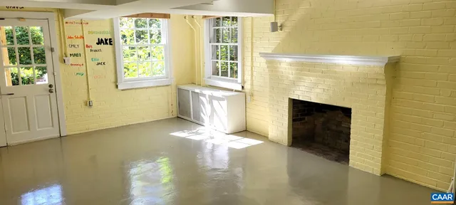 a view of an empty room with a fireplace and a window