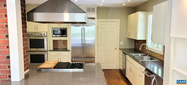 a kitchen with kitchen island granite countertop a stove a sink and a refrigerator