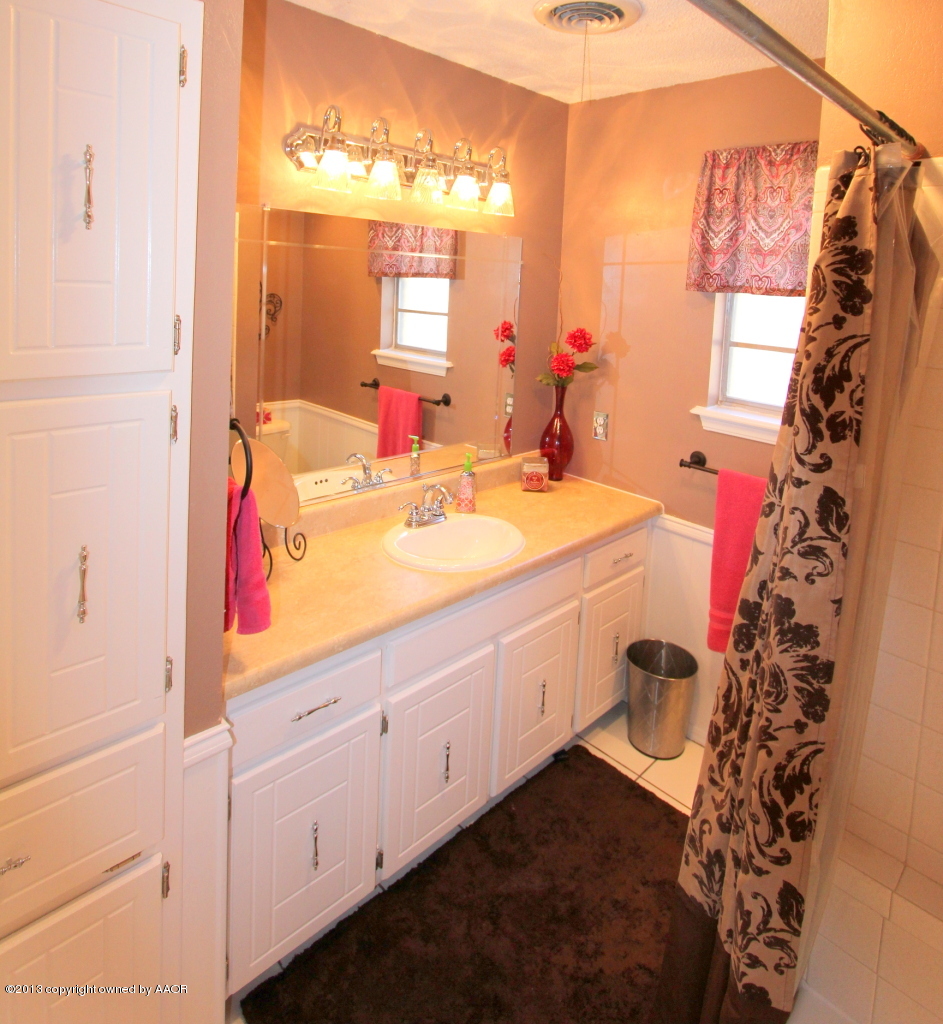 5304 South Fannin Street Amarillo, TX 79110 - Photo 12 of 23 a bathroom with a sink and a mirror