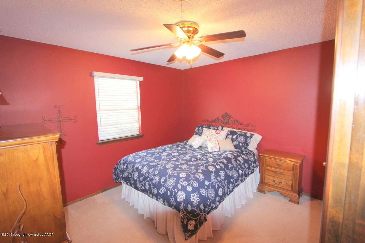 5304 South Fannin Street Amarillo, TX 79110 - Photo 13 of 23 a bedroom with a bed and a chandelier