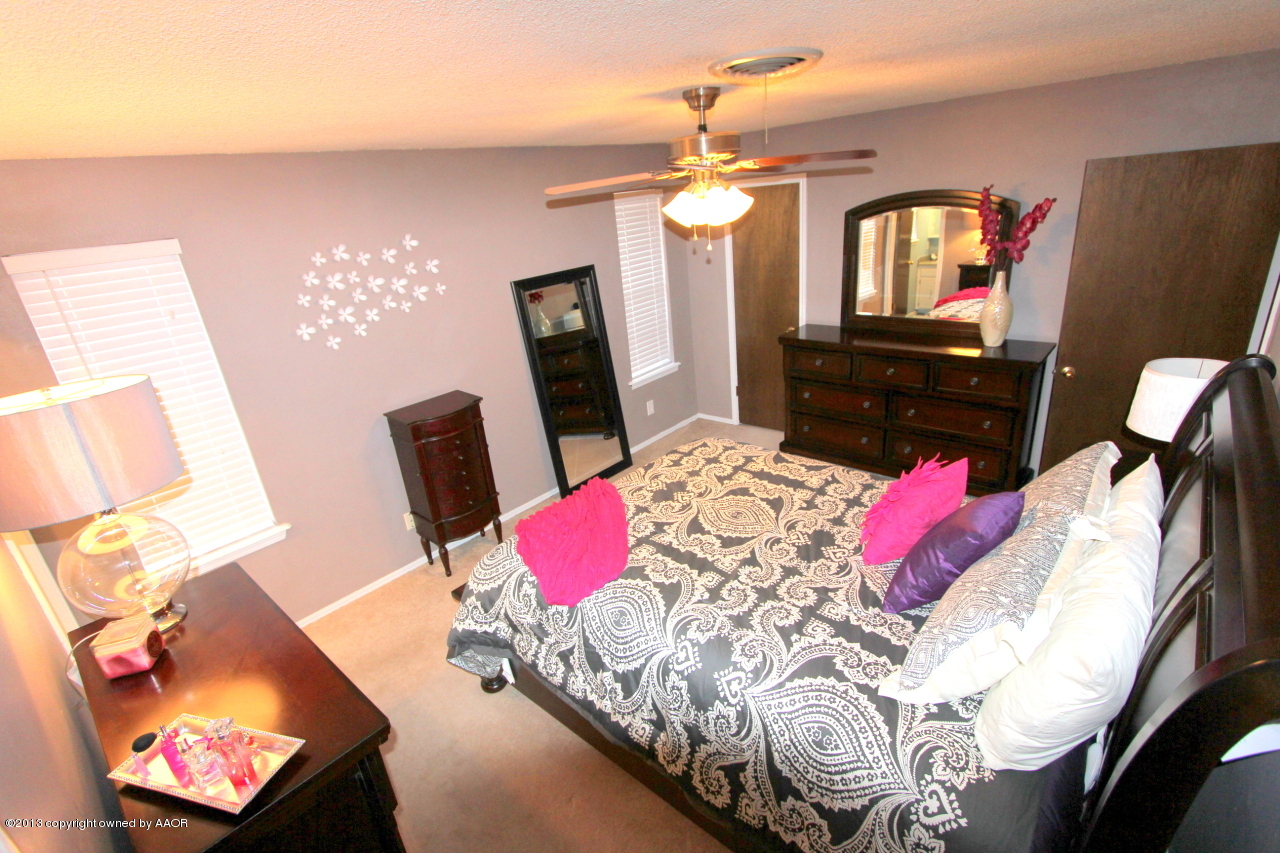5304 South Fannin Street Amarillo, TX 79110 - Photo 6 of 23 a bed room with a bed mirror and a flat screen tv