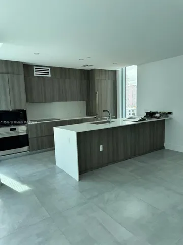a kitchen with stainless steel appliances granite countertop a refrigerator and a stove