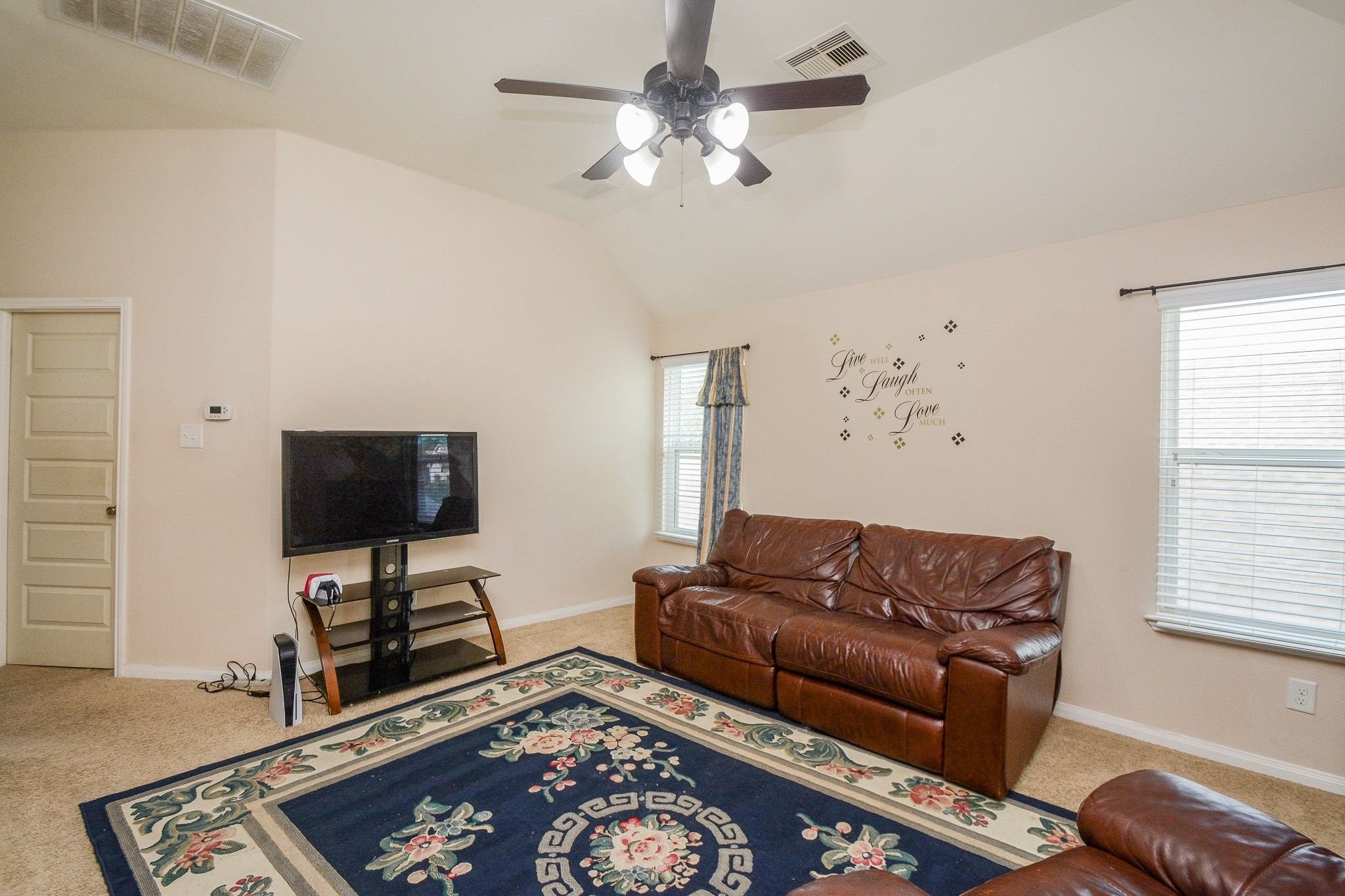 7046 Sliding Rock Circle Spring, TX 77379 - Photo 28 of 41 Spacious and inviting game room featuring a ceiling fan, cozy seating, and ample natural light—perfect for relaxation and entertainment.