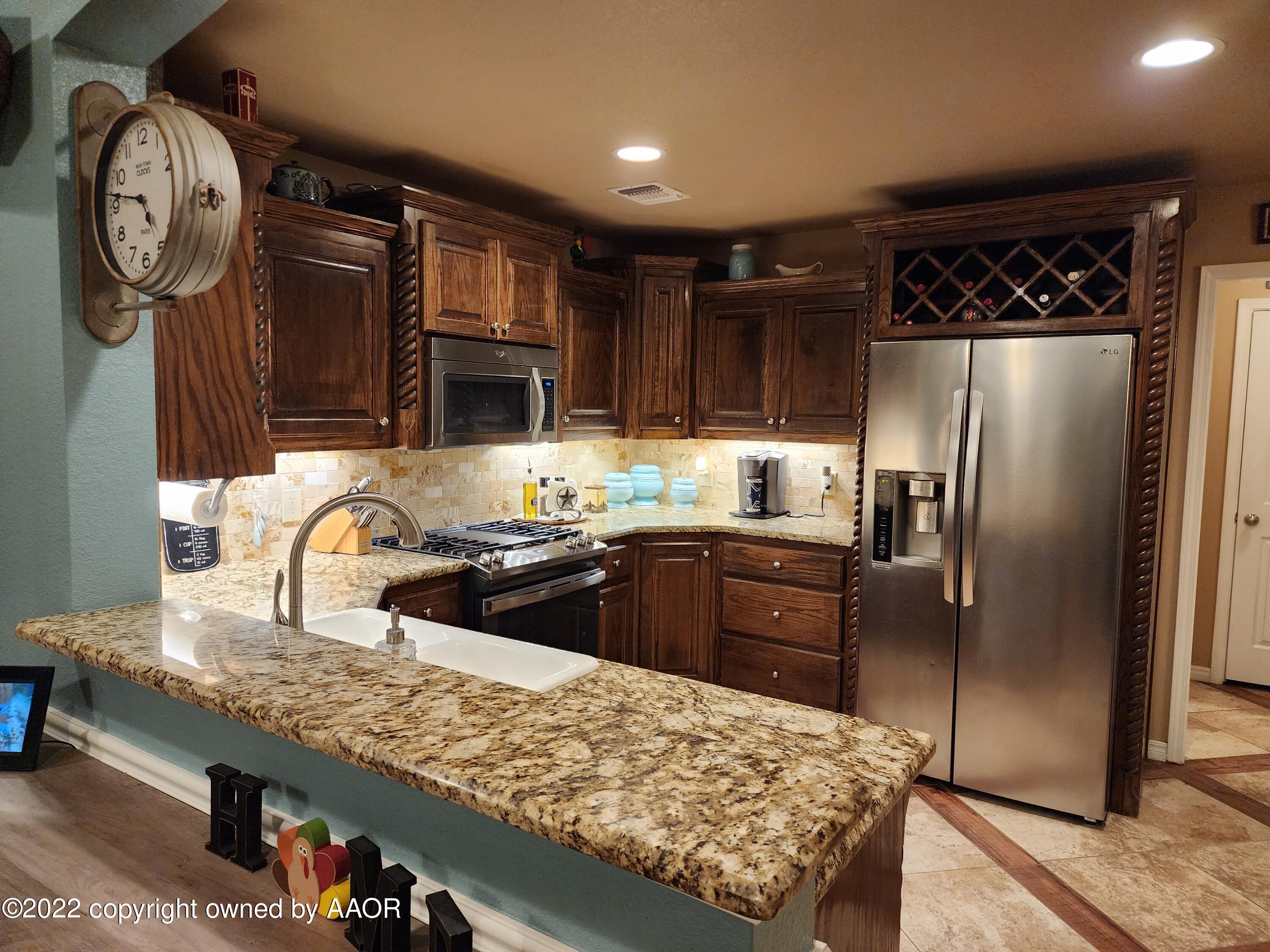 3912 Arden Road Amarillo, TX 79118 - Photo 11 of 35 a kitchen with stainless steel appliances granite countertop a refrigerator a sink and wooden cabinets