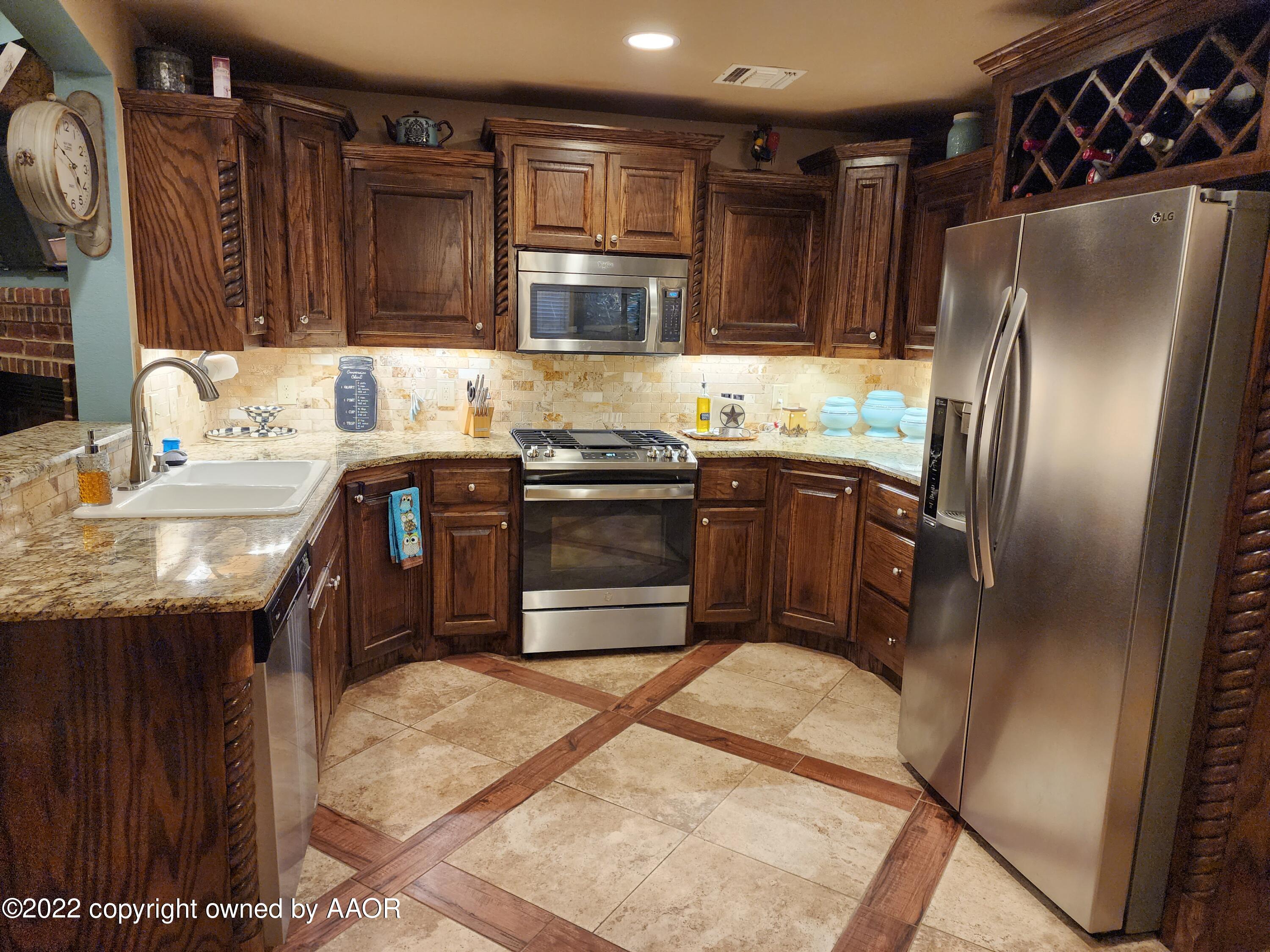 3912 Arden Road Amarillo, TX 79118 - Photo 13 of 35 a kitchen with stainless steel appliances granite countertop a sink stove and refrigerator