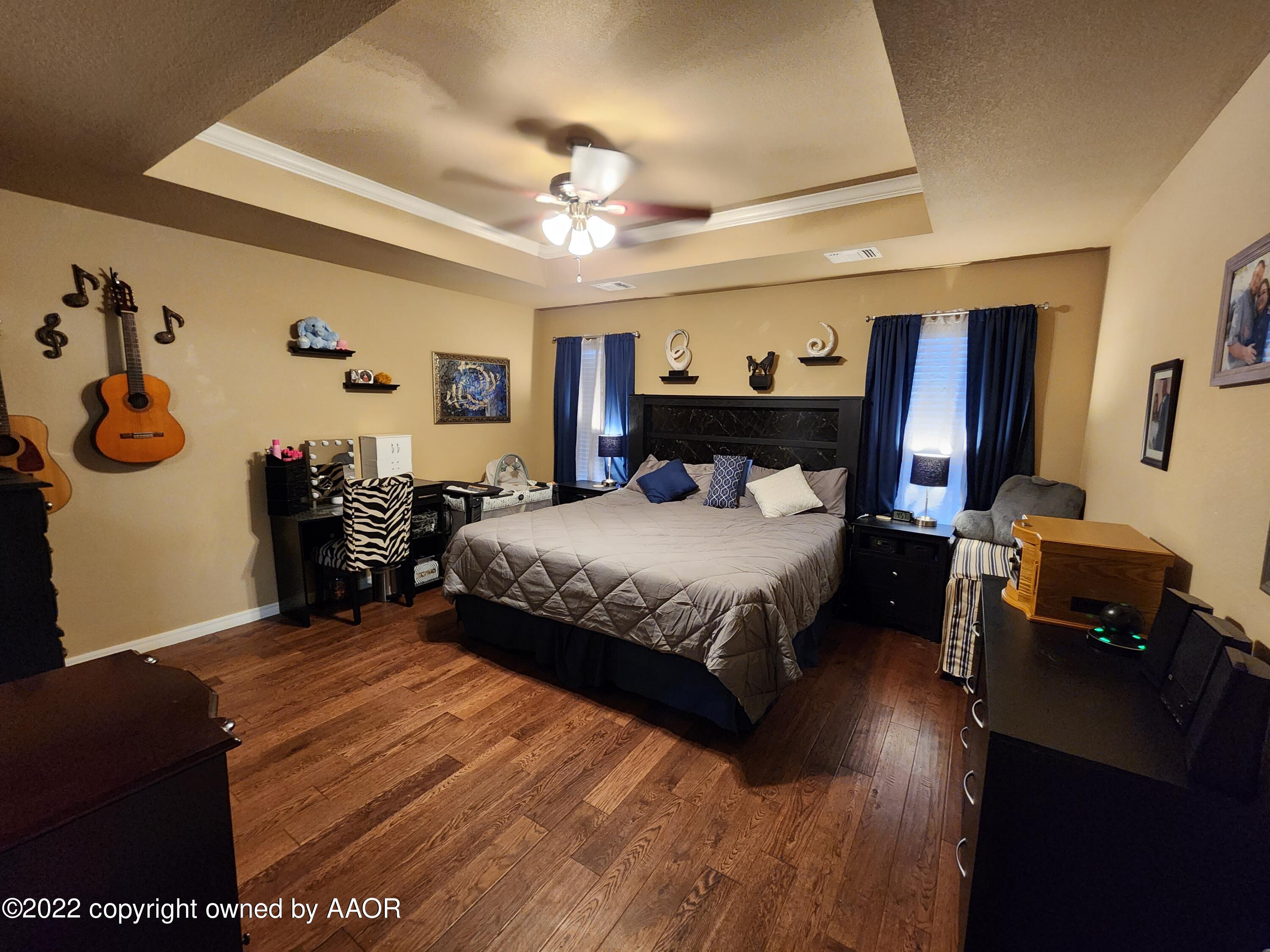 3912 Arden Road Amarillo, TX 79118 - Photo 17 of 35 a bedroom with a bed and wooden floor