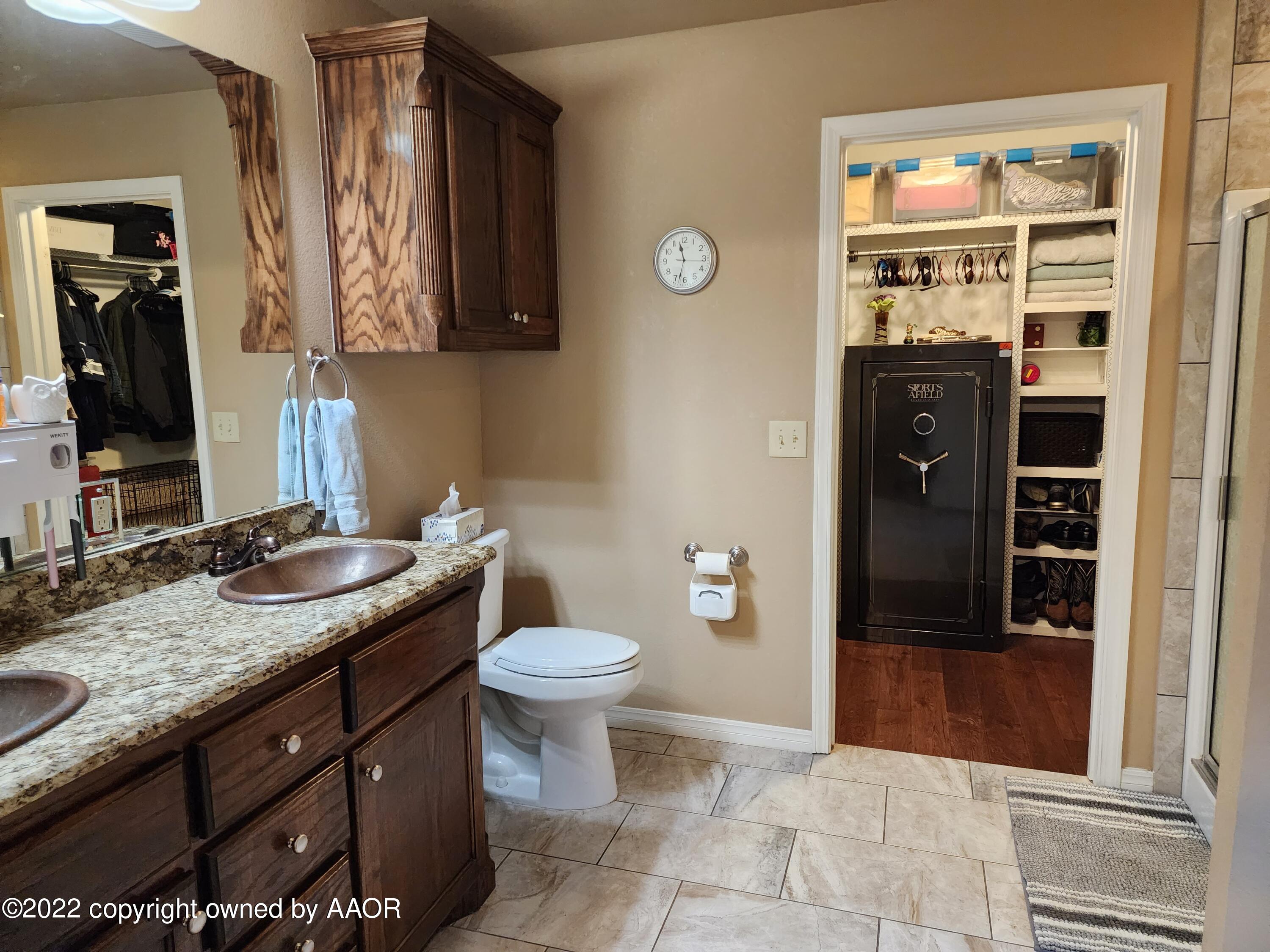 3912 Arden Road Amarillo, TX 79118 - Photo 20 of 35 a bathroom with a granite countertop sink a toilet and a mirror