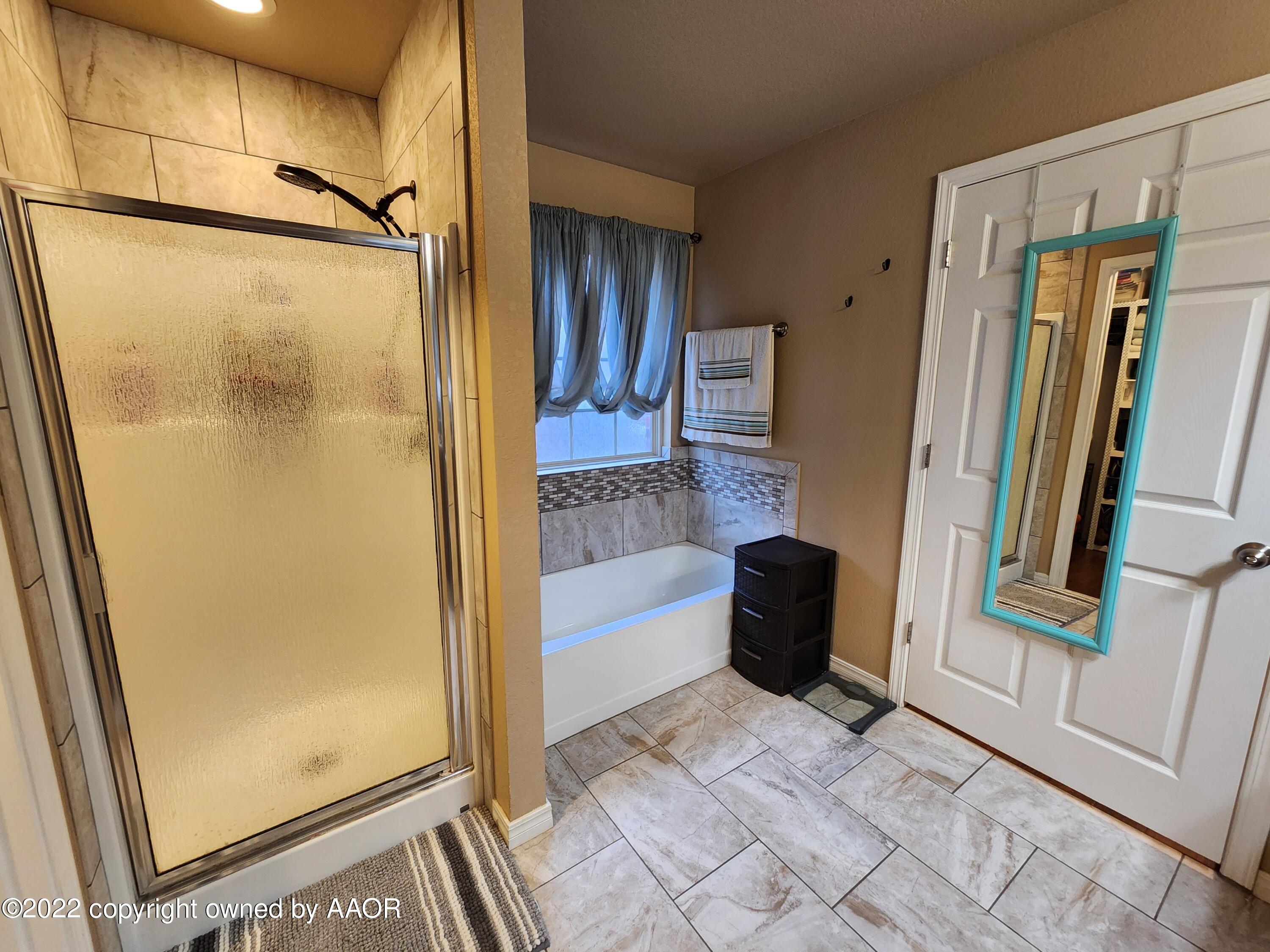 3912 Arden Road Amarillo, TX 79118 - Photo 24 of 35 a bathroom with a tub and a glass door shower