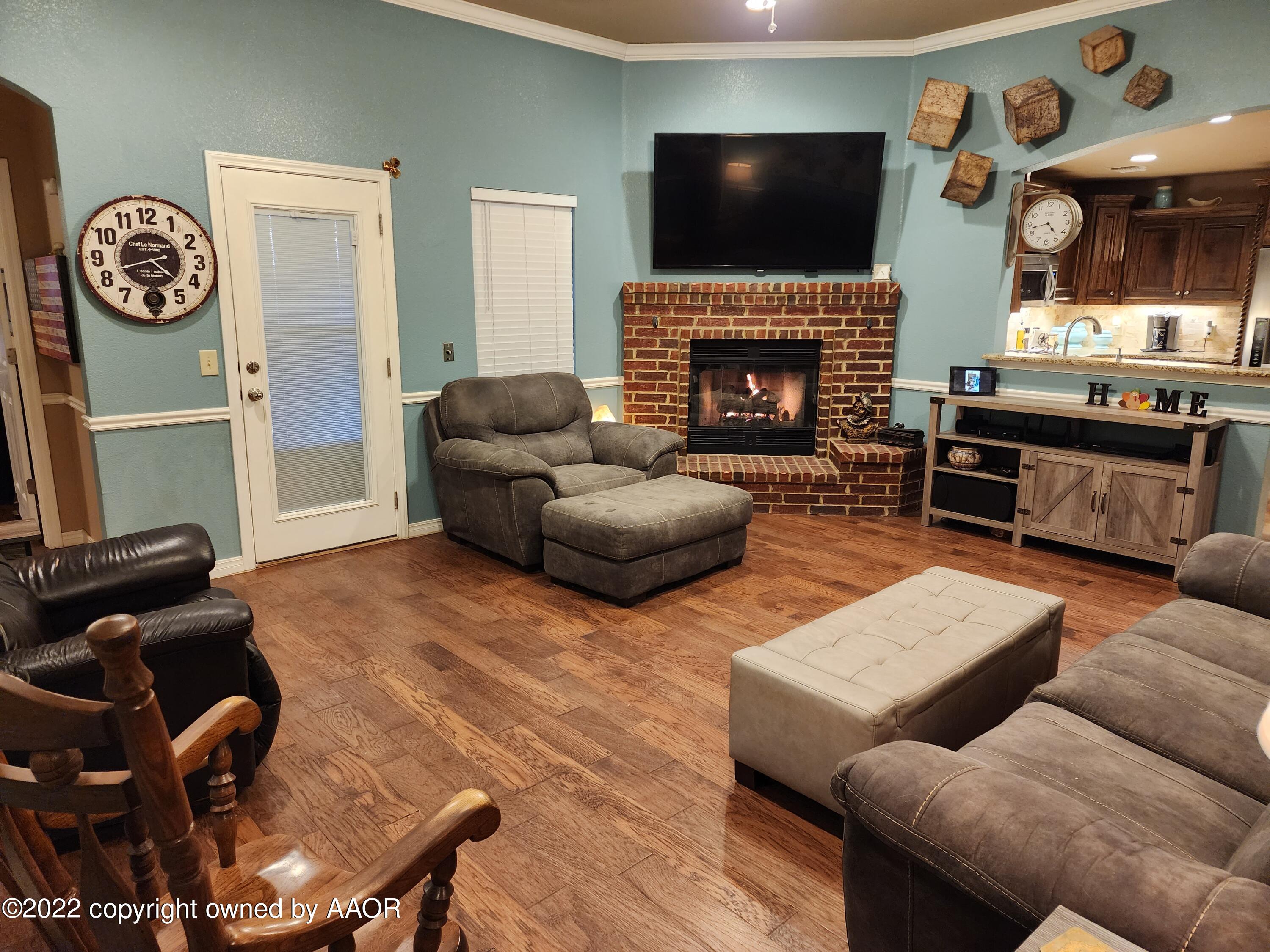 3912 Arden Road Amarillo, TX 79118 - Photo 9 of 35 a living room with furniture a flat screen tv and a fireplace