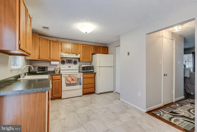 a kitchen with refrigerator stove microwave and sink