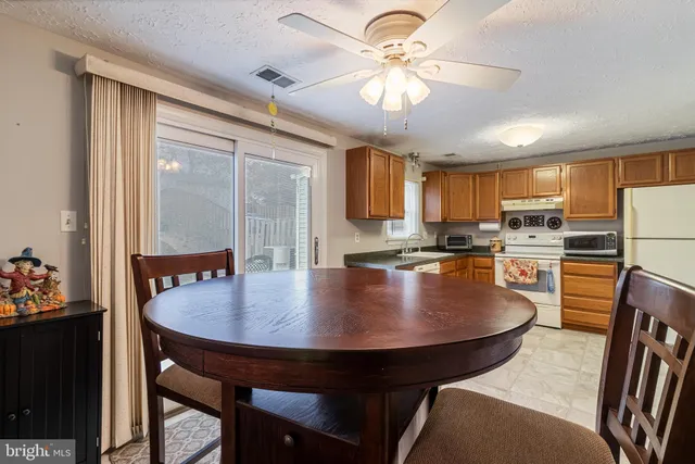 a kitchen with a dining table chairs and refrigerator