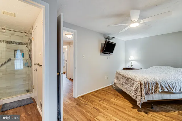 a bedroom with a bed and a flat tv screen on dresser