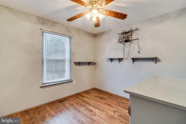 a view of empty room with a window and wooden floor
