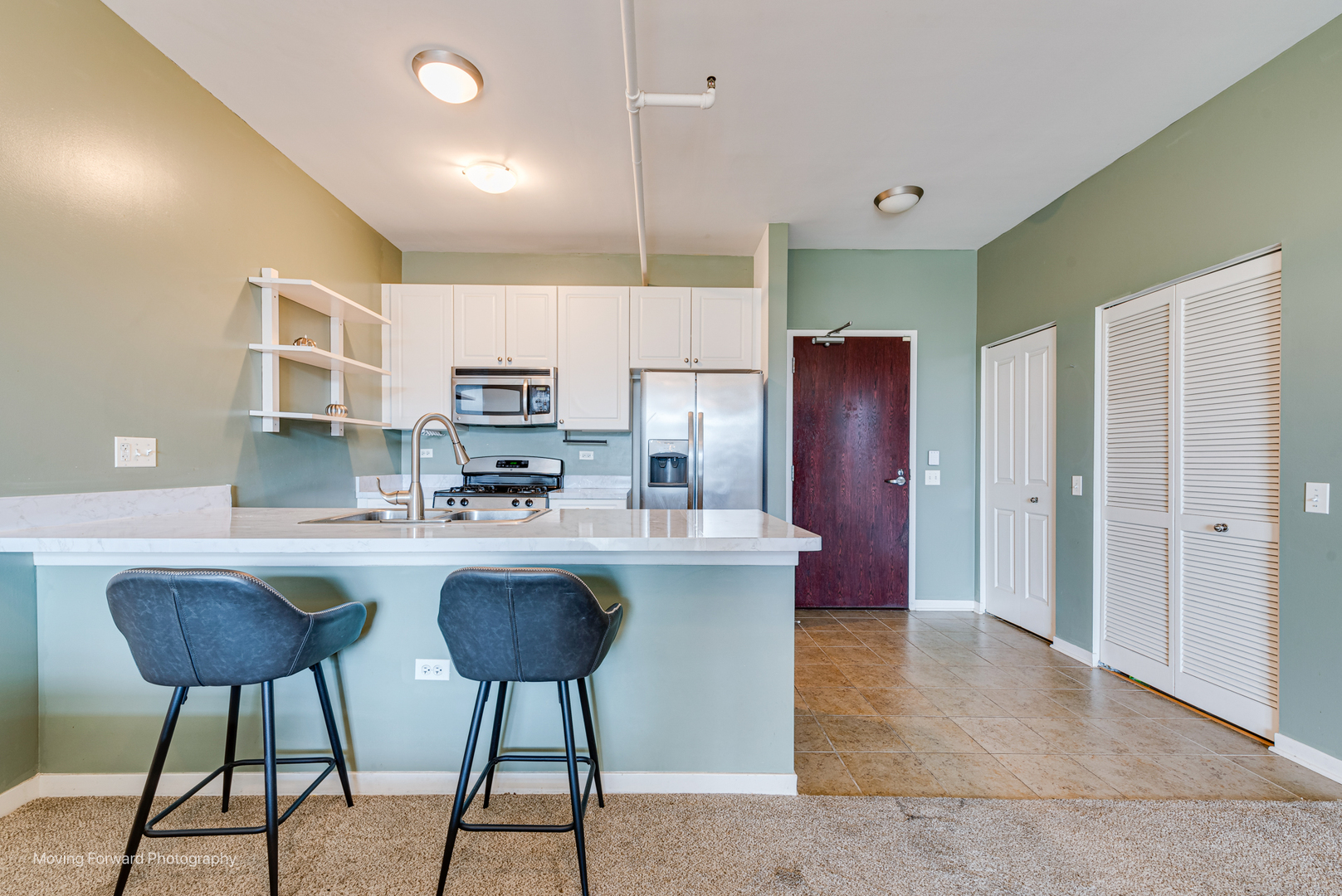 511 West Division Street, Unit 609 Chicago, IL 60610 - Photo 4 of 21 a kitchen with stainless steel appliances granite countertop a stove a refrigerator a kitchen island a stove and a center island