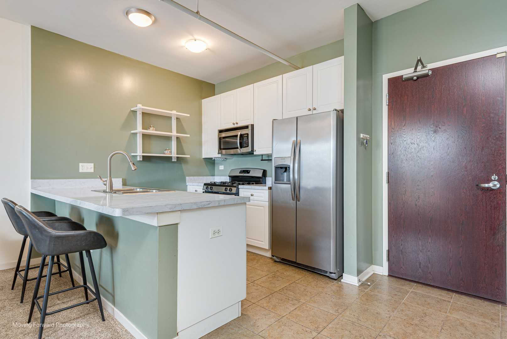 511 West Division Street, Unit 609 Chicago, IL 60610 - Photo 5 of 21 a kitchen with kitchen island a counter top space cabinets and stainless steel appliances
