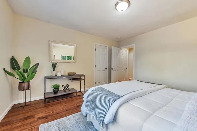 a bedroom with a bed and a potted plant